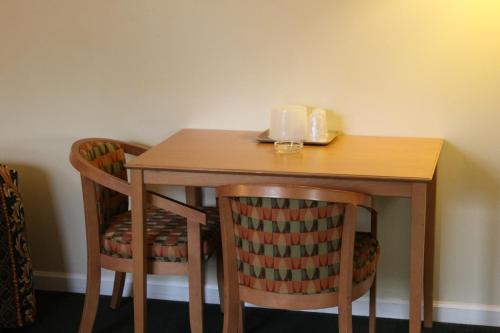 橋景鎮的住宿－布里奇維爾鈕瑞萊克斯酒店，一张带两把椅子的木桌和一张带蜡烛的桌子