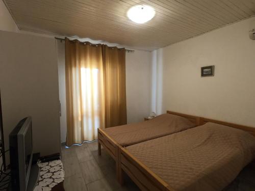 a small bedroom with a bed and a television at Villa Agata in Lastovo