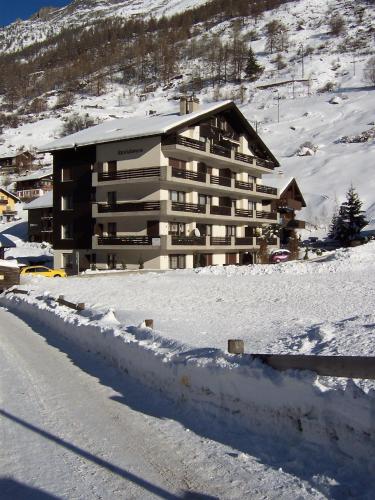 a large building in the snow in front of a mountain at Modern Täsch Apartment with Free Parking in Täsch