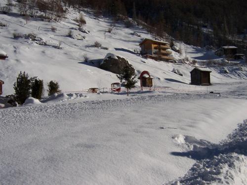a snow covered hillside with a building in the distance at Modern Täsch Apartment with Free Parking in Täsch