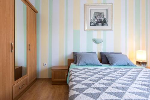 a bedroom with a bed with blue and white stripes at Holiday home Biondic in Krk
