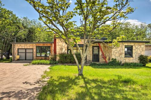 a house with a tree in front of it at Remodeled Retro Home with Deck, Walk to Main Street! in Blanco