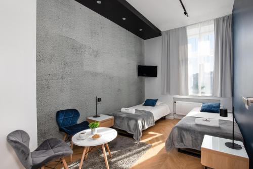 Habitación de hotel con 2 camas, mesa y sillas en Rainbow Apartments 3, en Cracovia