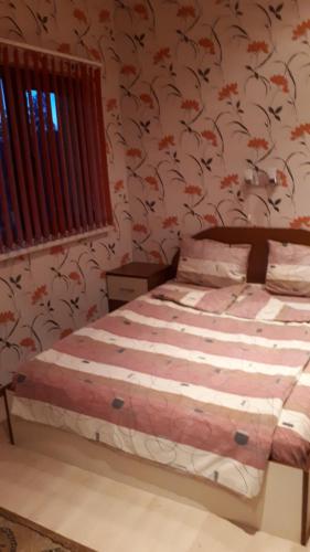 a bedroom with a bed with floral wallpaper at Guest House Blisten in Sofia