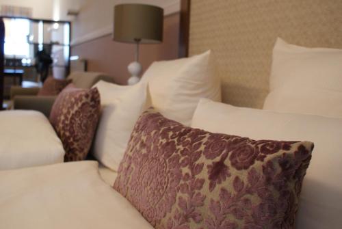 a pile of pillows on a bed in a hotel room at Aparthotel Am Schloss in Dresden