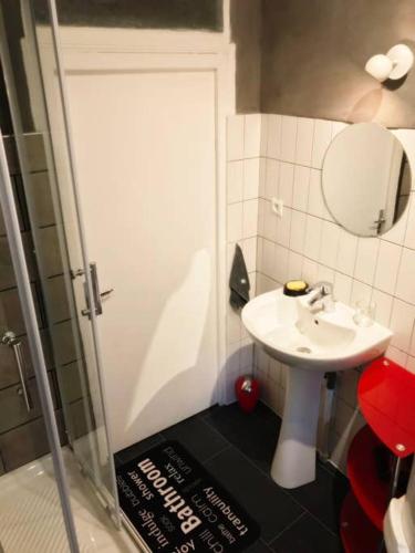 une petite salle de bain avec un lavabo et un miroir dans l'établissement Le Logis, au cœur de la ville à l'ascension du château !, à Saumur