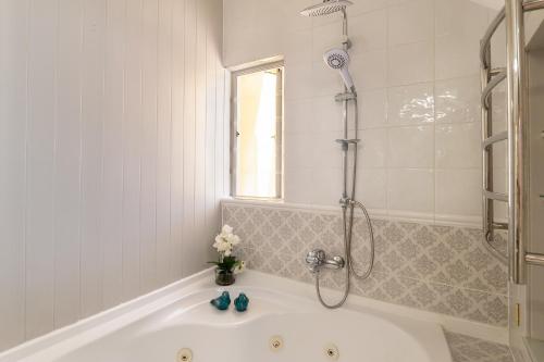 a bathroom with a bath tub with a shower at Haus am Strand - on the Beach in Wilderness