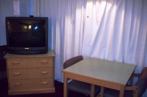 a small tv sitting on top of a wooden table at Hilander Motel in Mountain Home