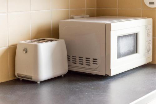 a microwave and a toaster sitting on a counter at EDINBURGH CITY CENTRE AISHIA/SAKINA APARTMENT in Edinburgh