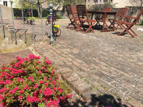 a patio with flowers and a table and chairs at Augustodun'Home in Autun