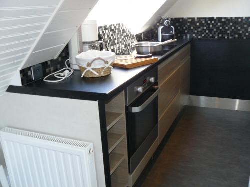 une cuisine avec un comptoir noir et blanc dans l'établissement SAUVAGERE - Studio balcon, Plage 300m - UD67, à Carnac