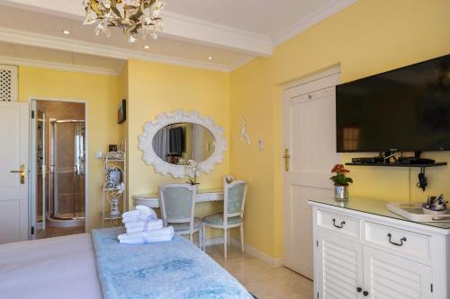 a bedroom with a bed and a desk and a mirror at Haus am Strand - on the Beach in Wilderness