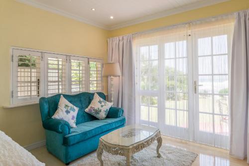 a living room with a blue couch and a coffee table at Haus am Strand - on the Beach in Wilderness