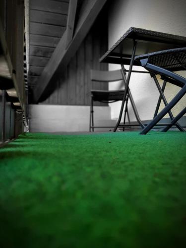 a room with green carpet and a table and chairs at Hotel Landgasthof Frankenstern in Gößweinstein