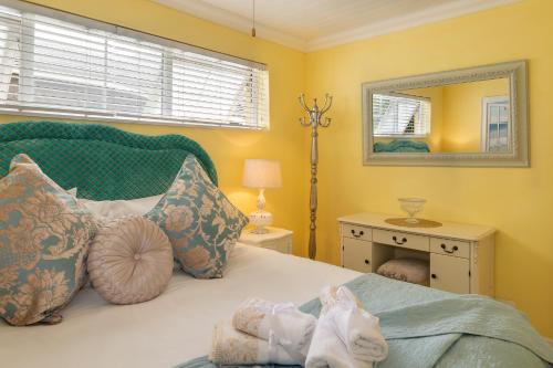 a bedroom with a bed with a mirror on the wall at Haus am Strand - on the Beach in Wilderness