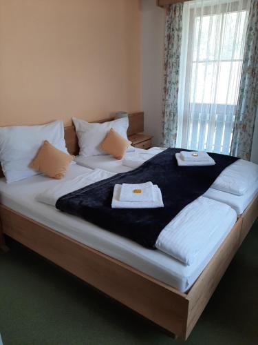 a large bed with two towels on top of it at Hotel Landgasthof Frankenstern in Gößweinstein