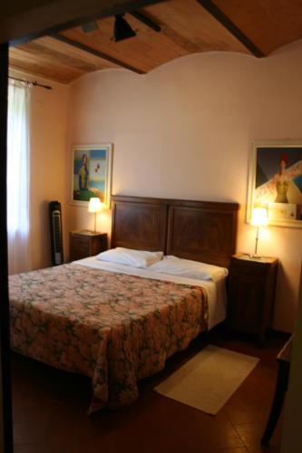 a bedroom with a bed and two lamps in a room at Podere Il Trebbio, porzione di villa in Gaiole in Chianti