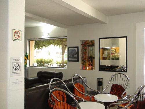 a waiting room with tables and chairs and a couch at Hotel Panuco in Mexico City