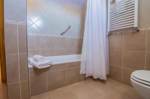 y baño con ducha, aseo y cortina de ducha. en Hostería Vertical Lodge en El Chalten