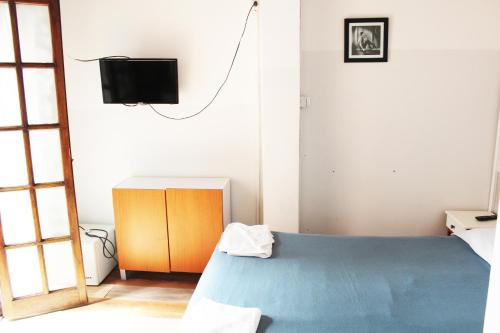 a bedroom with a blue bed and a tv at Cañitas Home in Buenos Aires