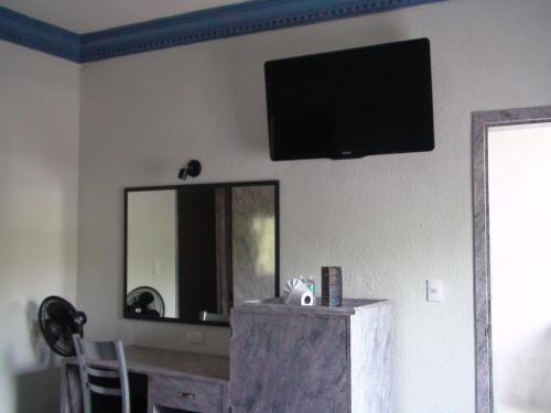 a flat screen tv on a wall with a mirror at Hotel Panuco in Mexico City
