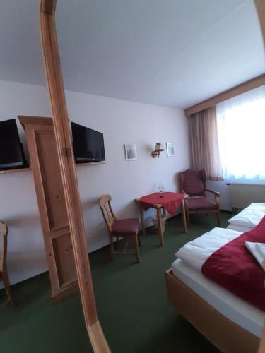 ein Hotelzimmer mit einem Bett, einem Tisch und Stühlen in der Unterkunft Hotel Landgasthof Frankenstern in Gößweinstein