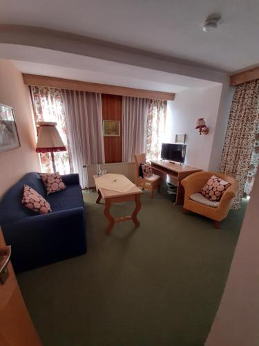 a living room with a couch and a table at Hotel Landgasthof Frankenstern in Gößweinstein