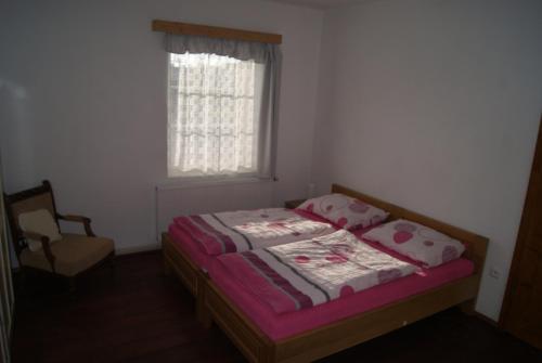 1 dormitorio con 1 cama, 1 silla y 1 ventana en Apartmán Český ráj, en Turnov