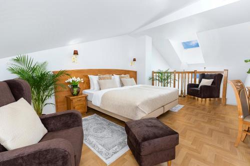 a bedroom with a bed and two chairs at Ventus Rosa Boutique Aparthotel in Kraków