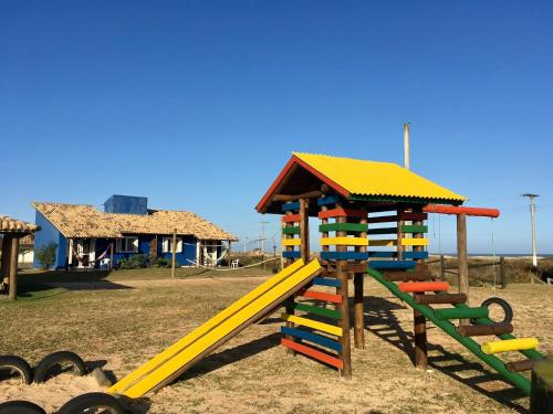 a playground with a slide and a play structure at Pousada dos Sambaquis in Jaguaruna