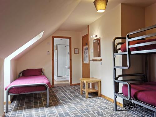 a room with two bunk beds and a table at Morag's Lodge in Fort Augustus