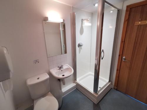 a bathroom with a toilet, sink, and shower at Morag's Lodge in Fort Augustus