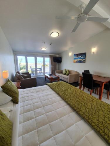 a living room with a large bed and a table at Baileys At The Beach in Whitianga