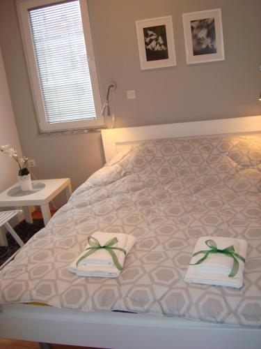 a bedroom with a bed with two towels and a window at Apartments Nela in Ohrid