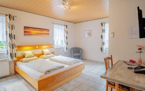 sypialnia z łóżkiem i biurkiem w obiekcie Hotel Ulftaler Schenke w mieście Burg-Reuland