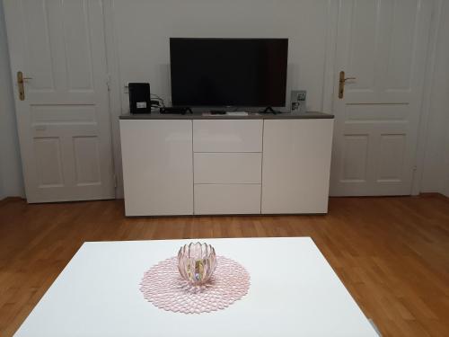 a living room with a television on a white cabinet at Apartman Kod Kestena in Osijek
