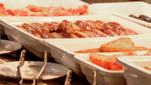 a bunch of trays of food on a table at Holiday Inn Maidstone-Sevenoaks by IHG in Maidstone