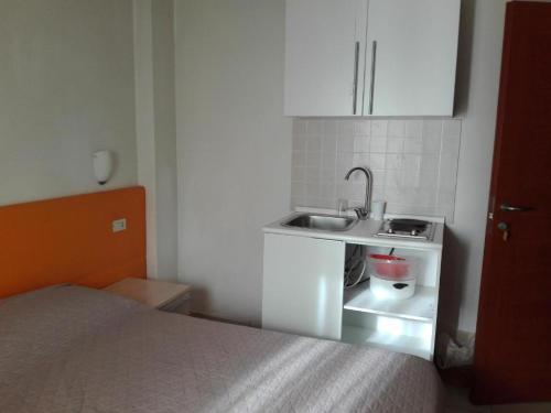a small kitchen with a sink and a bed at New Prophet Appartamenti in Cattolica