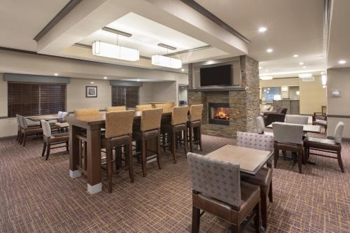 a restaurant with a fireplace and tables and chairs at Holiday Inn Express & Suites Yankton by IHG in Yankton