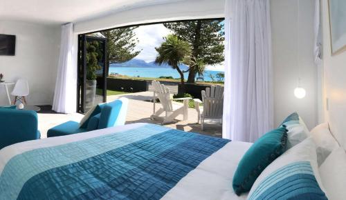 a bedroom with a bed and a view of the ocean at The Hamptons in Kaikoura