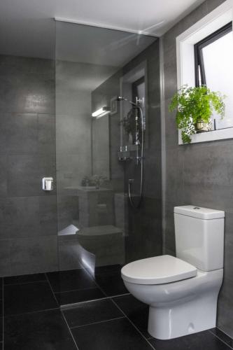 a bathroom with a toilet and a glass shower at The Hamptons in Kaikoura