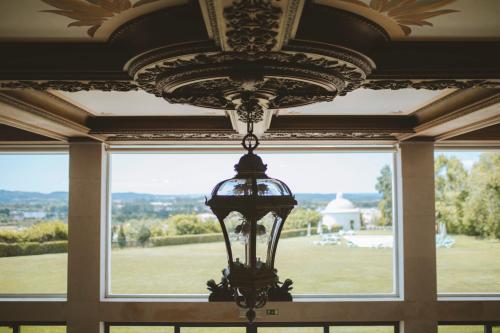 a chandelier hanging from a ceiling in front of a window at Conimbriga Hotel do Paço in Condeixa a Nova