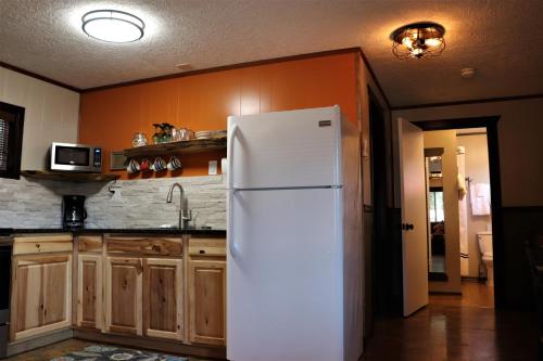 a white refrigerator in a kitchen with wooden cabinets at Lone Fir Resort in Cougar
