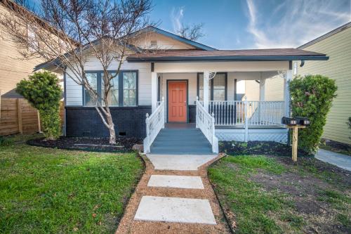 a white house with a red door and a yard at Downtown View Cozy 2BR1BA Home Sleeps 8 in San Antonio