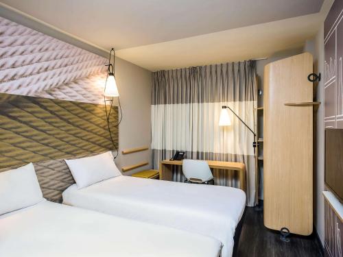 um quarto de hotel com duas camas e uma secretária em ibis Fortaleza Centro de Eventos em Fortaleza
