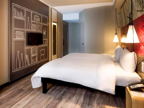 a bedroom with a large white bed and a chalkboard wall at Ibis Istanbul West in Istanbul