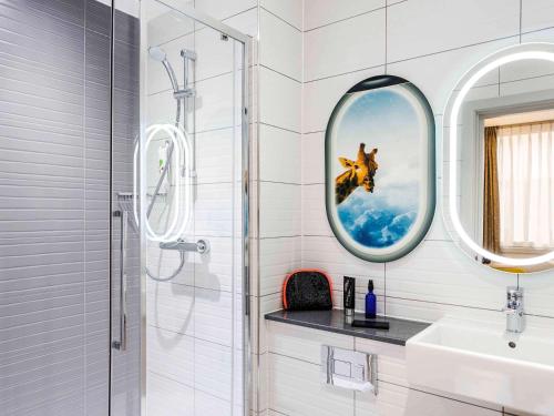 
a bathroom with a shower, sink, and mirror at ibis Styles London Heathrow Airport in Hillingdon
