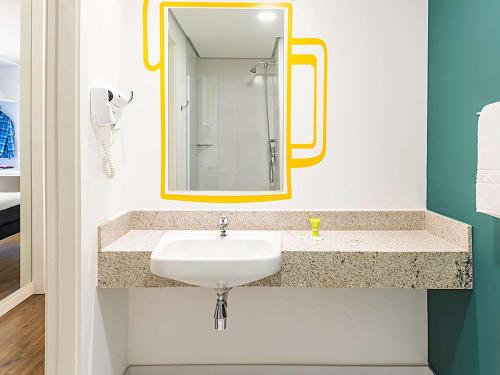 La salle de bains est pourvue d'un lavabo et d'un miroir. dans l'établissement ibis Styles Ribeirao Preto Jardim Botanico, à Ribeirão Preto