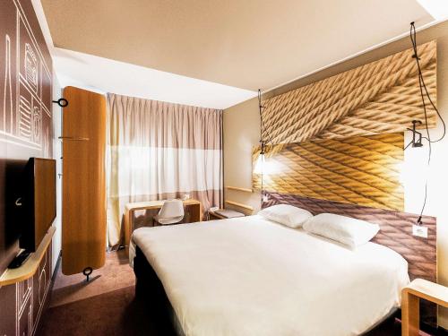 Ένα ή περισσότερα κρεβάτια σε δωμάτιο στο Ibis Poznan Polnoc