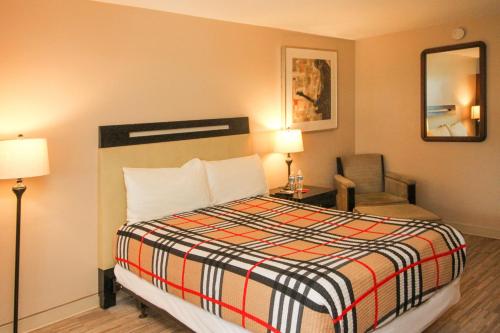 マーティンズバーグにあるAPM Inn & Suitesのベッドと椅子付きのホテルルーム